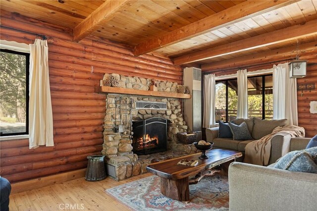 living room with rustic walls, beamed ceiling, a stone fireplace, hardwood / wood-style flooring, and wooden ceiling
