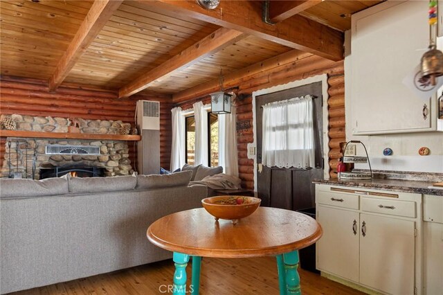 kitchen with light wood-type flooring, log walls, wood ceiling, and beamed ceiling