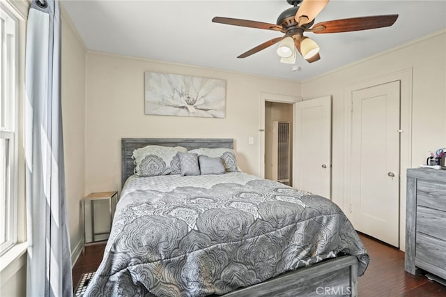 bedroom featuring ornamental molding, a ceiling fan, and wood finished floors