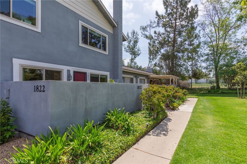 1822 Aleppo Ct, Thousand Oaks, CA 91362 - view of side of property with a lawn, stucco siding, a chimney, and fence