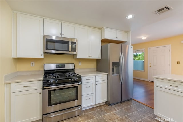 kitchen with white cabinets, light countertops, stainless steel appliances, recessed lighting, and visible vents