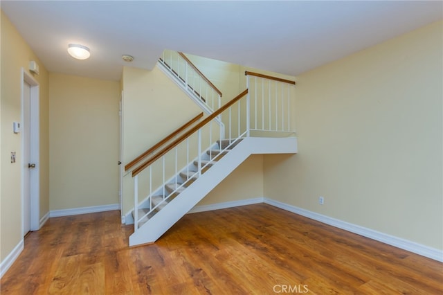 stairway featuring baseboards and wood finished floors