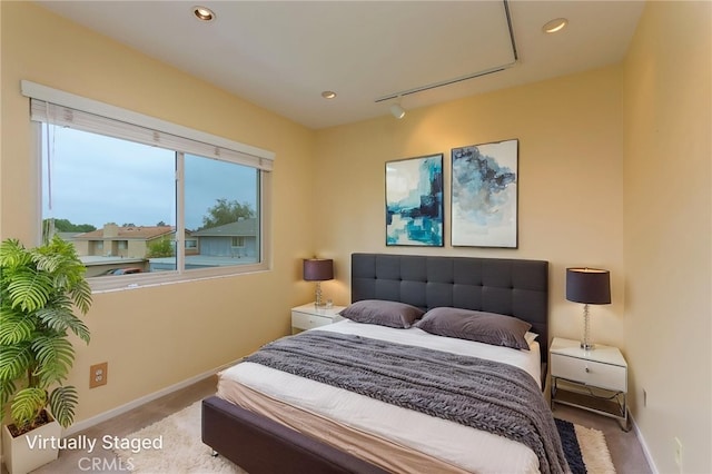 carpeted bedroom with recessed lighting, baseboards, track lighting, and attic access