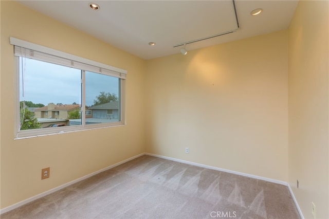 spare room with light colored carpet, recessed lighting, baseboards, and track lighting