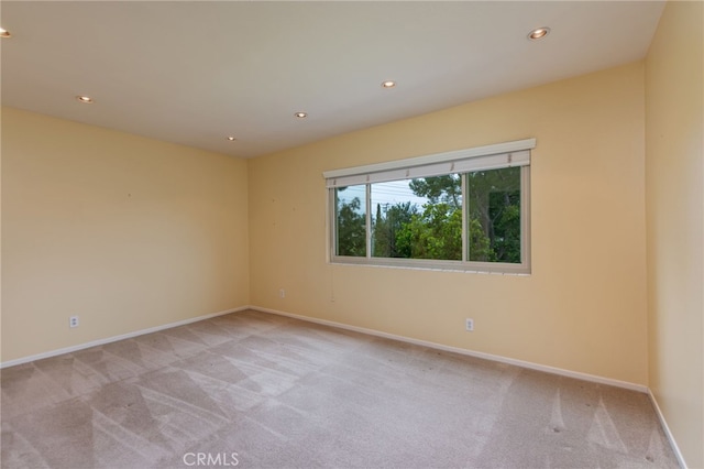 unfurnished room featuring recessed lighting, baseboards, and light colored carpet