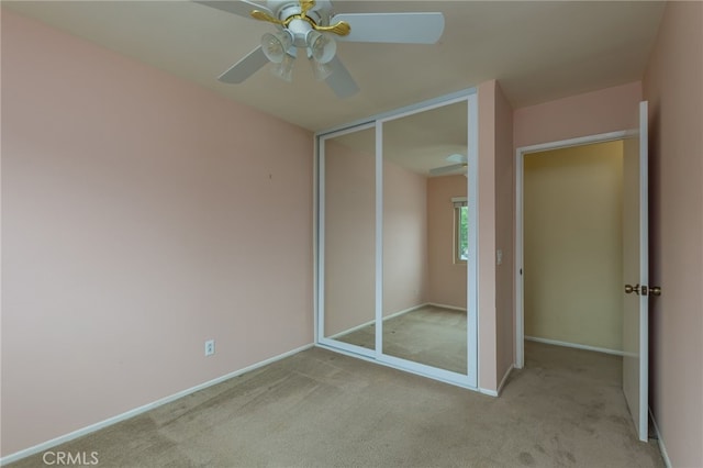 unfurnished bedroom with carpet floors, a ceiling fan, baseboards, and a closet