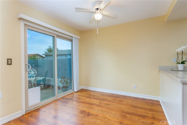 spare room with baseboards, a ceiling fan, and wood finished floors