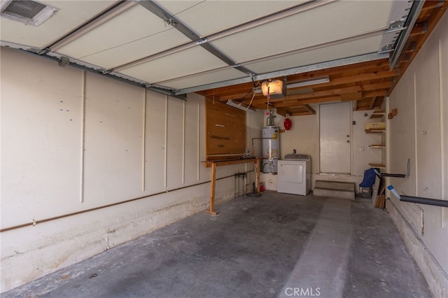 garage with strapped water heater and washer / dryer