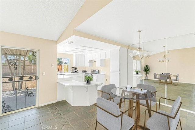 dining space featuring a healthy amount of sunlight, baseboards, an inviting chandelier, and vaulted ceiling