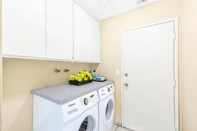 clothes washing area with visible vents, cabinet space, and independent washer and dryer