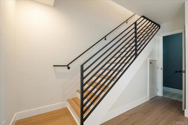 stairway with baseboards and wood finished floors
