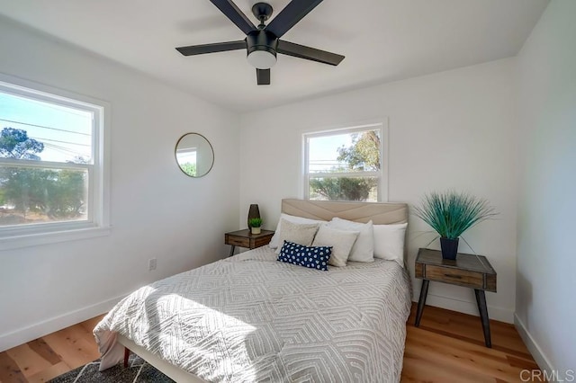 bedroom featuring light wood-style floors, baseboards, and ceiling fan