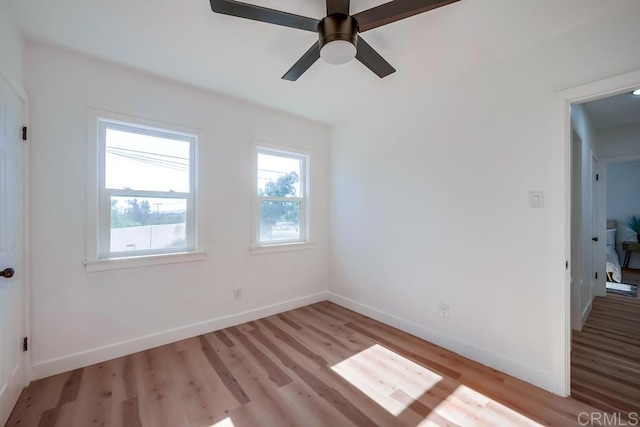 spare room with light wood-style floors, baseboards, and ceiling fan