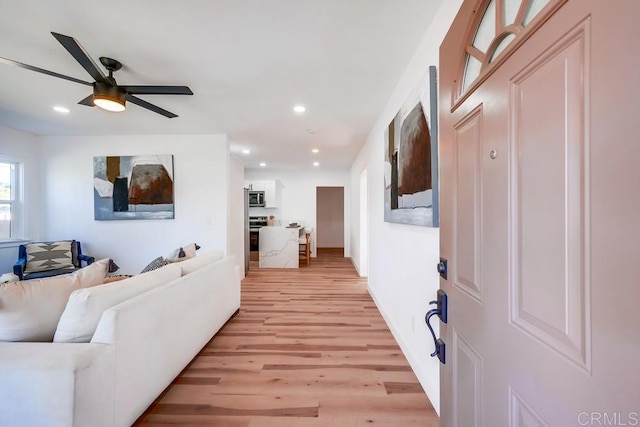 living room with recessed lighting, a ceiling fan, and light wood-style floors