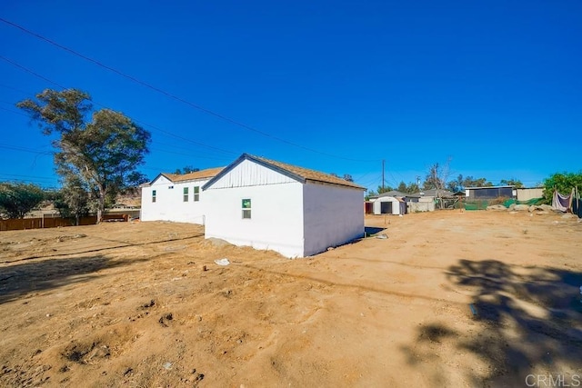 view of side of home featuring fence