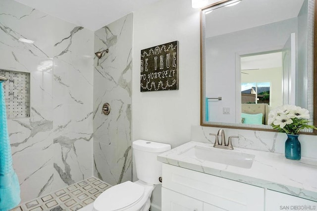 bathroom featuring a marble finish shower, vanity, and toilet