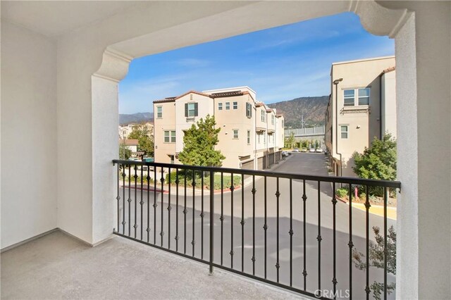 balcony featuring a residential view and a mountain view