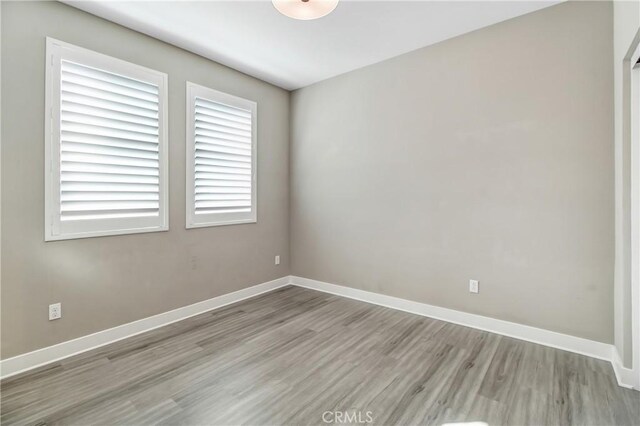 empty room with baseboards and wood finished floors