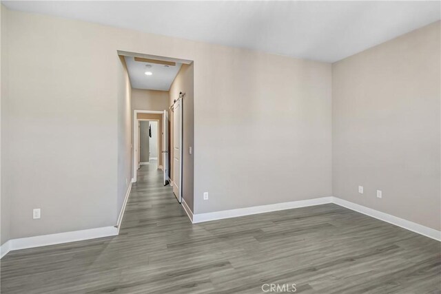 empty room featuring baseboards and wood finished floors