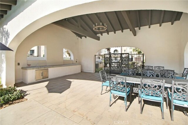 view of patio with a sink, exterior kitchen, fence, and outdoor dining area