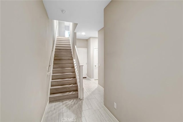 stairway featuring baseboards and tile patterned flooring