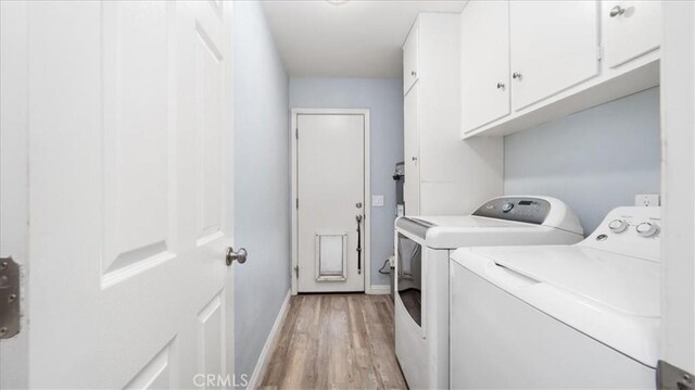washroom with light wood-type flooring, washer and clothes dryer, cabinet space, and baseboards