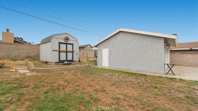 view of yard with a storage unit, fence, and an outbuilding