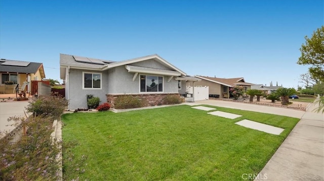ranch-style house featuring brick siding, a front lawn, stucco siding, and solar panels