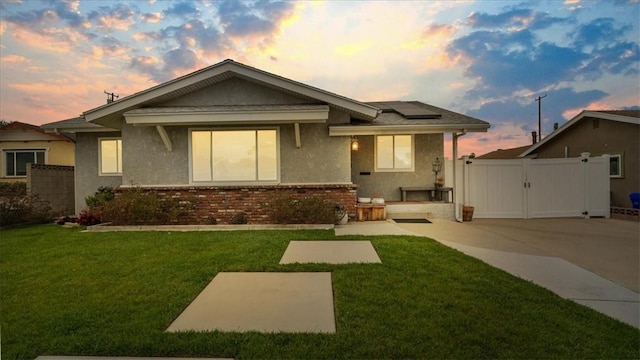 exterior space featuring fence, a gate, a yard, and solar panels