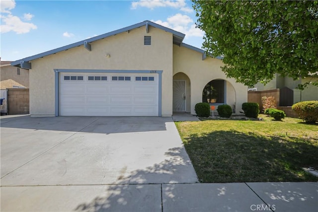 view of front facade featuring fence, a front lawn, a garage, stucco siding, and driveway