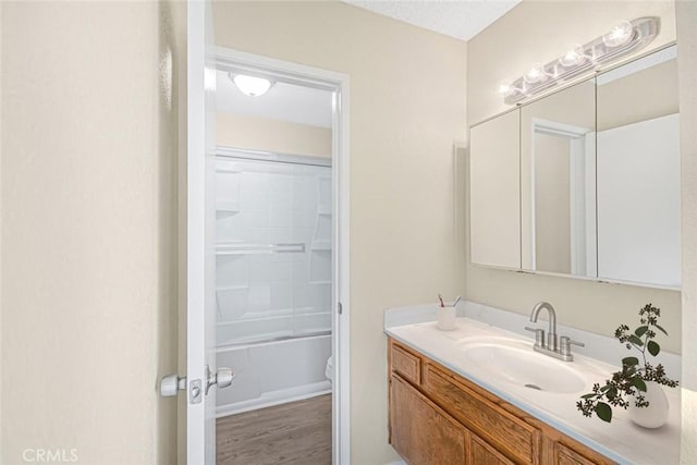 bathroom featuring vanity, tub / shower combination, wood finished floors, and toilet
