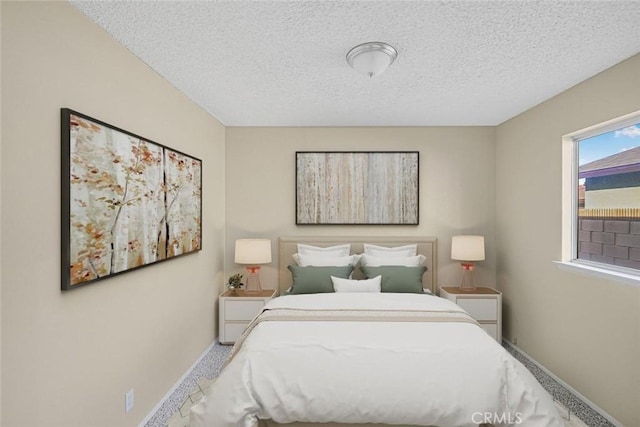 carpeted bedroom with baseboards and a textured ceiling