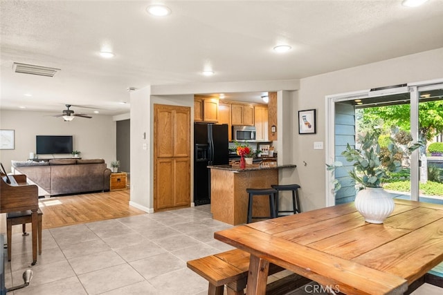interior space featuring ceiling fan, visible vents, light tile patterned floors, baseboards, and recessed lighting