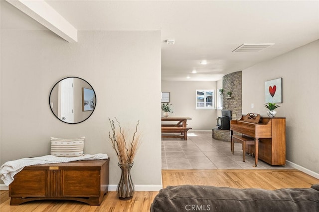 hall with baseboards, wood finished floors, and visible vents