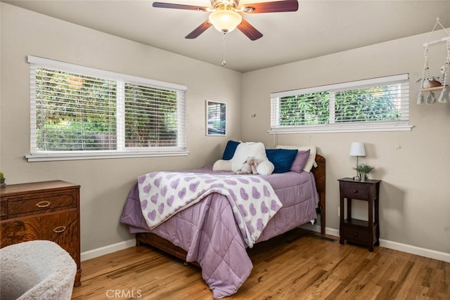 bedroom with baseboards, light wood finished floors, and ceiling fan
