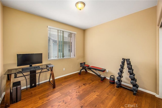 workout area featuring baseboards and wood finished floors