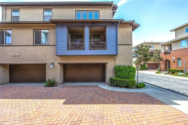 townhome / multi-family property featuring an attached garage, driveway, and stucco siding