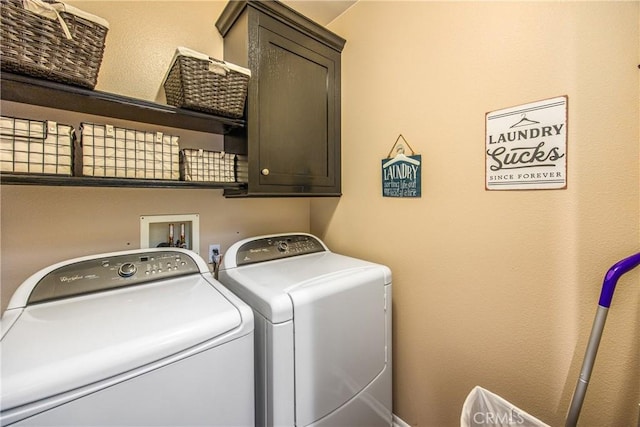 clothes washing area featuring washing machine and clothes dryer and cabinet space