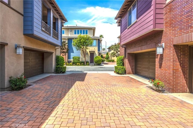 view of community featuring decorative driveway and a garage