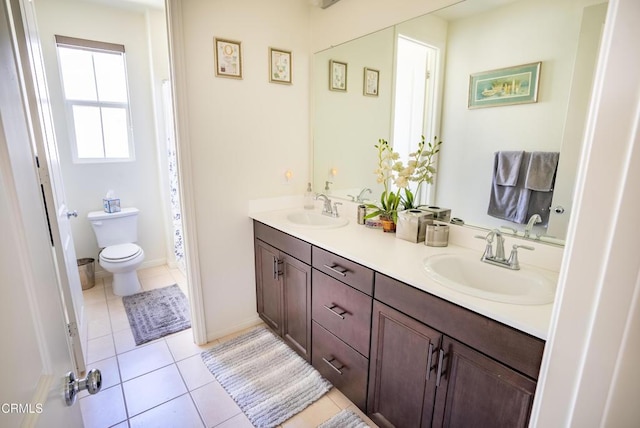 bathroom featuring double vanity, a sink, tile patterned floors, and toilet