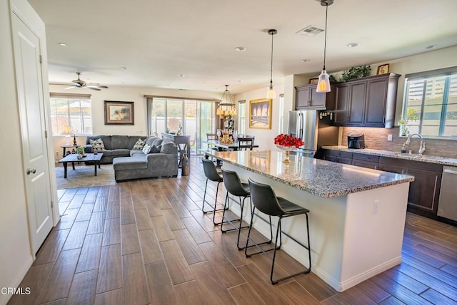 kitchen with a kitchen island, visible vents, appliances with stainless steel finishes, dark wood finished floors, and a sink