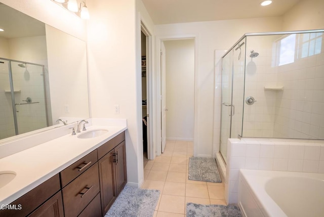 bathroom featuring a sink, double vanity, tile patterned floors, a shower stall, and a garden tub