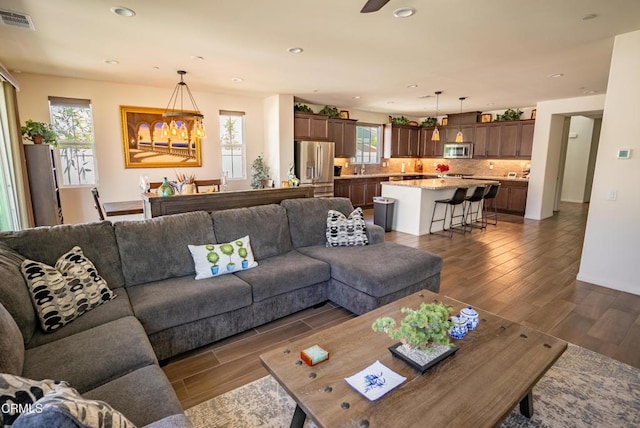 living room featuring recessed lighting, visible vents, and dark wood-type flooring