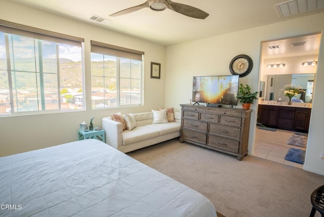 bedroom featuring visible vents, light carpet, and multiple windows
