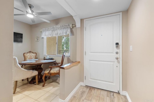 doorway to outside with a ceiling fan, baseboards, and light wood finished floors