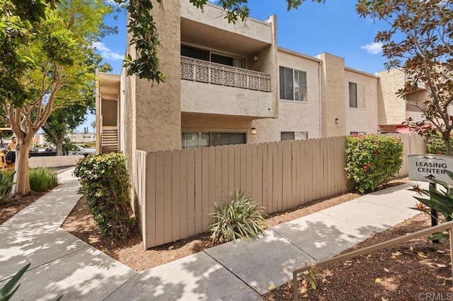 view of home's exterior featuring stucco siding and fence
