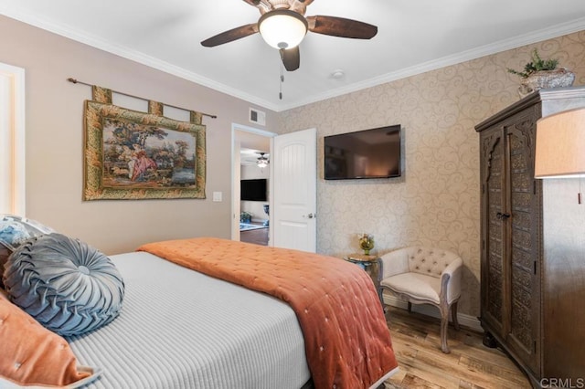 bedroom featuring visible vents, ornamental molding, light wood finished floors, and wallpapered walls