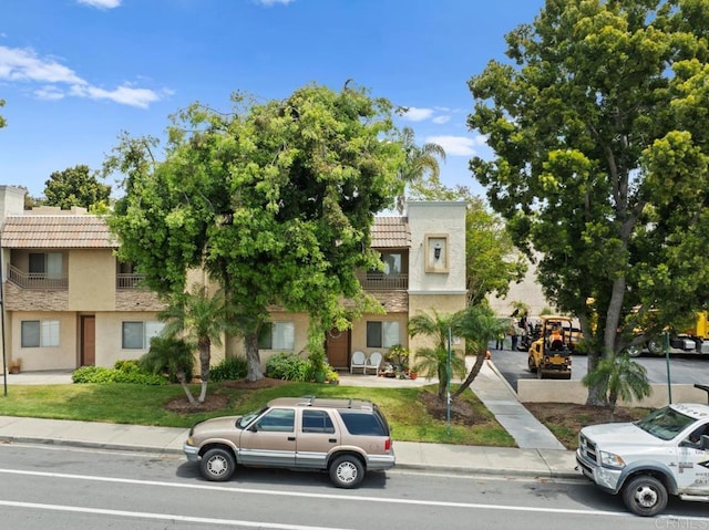 view of property with a tile roof and stucco siding
