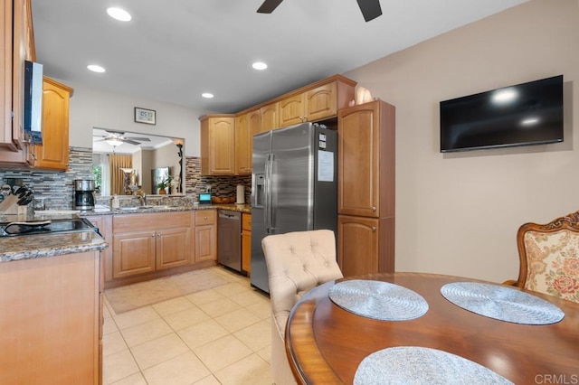 kitchen featuring a sink, ceiling fan, backsplash, and stainless steel appliances