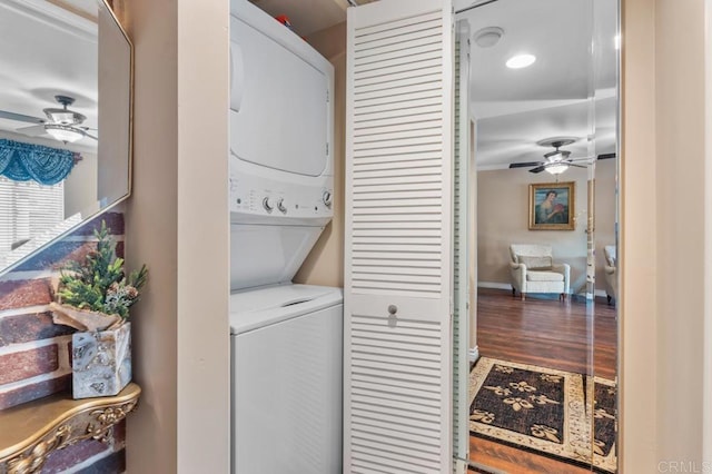laundry room with laundry area, stacked washer and clothes dryer, a ceiling fan, and wood finished floors